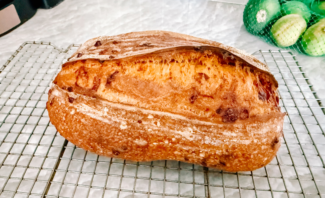 Maggie’s golden house sourdough loaf cooling on a wire rack