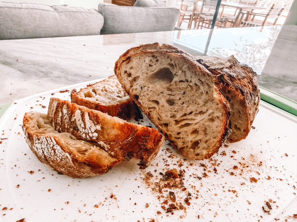 Maggie’s rustic sourdough loaf sliced on a cutting board